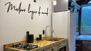 A rustic kitchen with a wooden island, a white refrigerator, and a wall-mounted sign. - Recanto Due Fratelli (Passo de Torres)