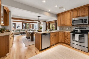 Una cocina moderna con armarios de madera, electrodomésticos de acero inoxidable y una isla central.
