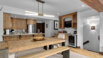 Een moderne keuken met houten kasten, een roestvrijstalen koelkast en een inbouwoven.
