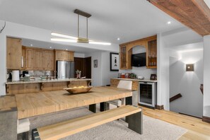 A modern kitchen with wooden cabinets, a stainless steel refrigerator, and a built-in oven.