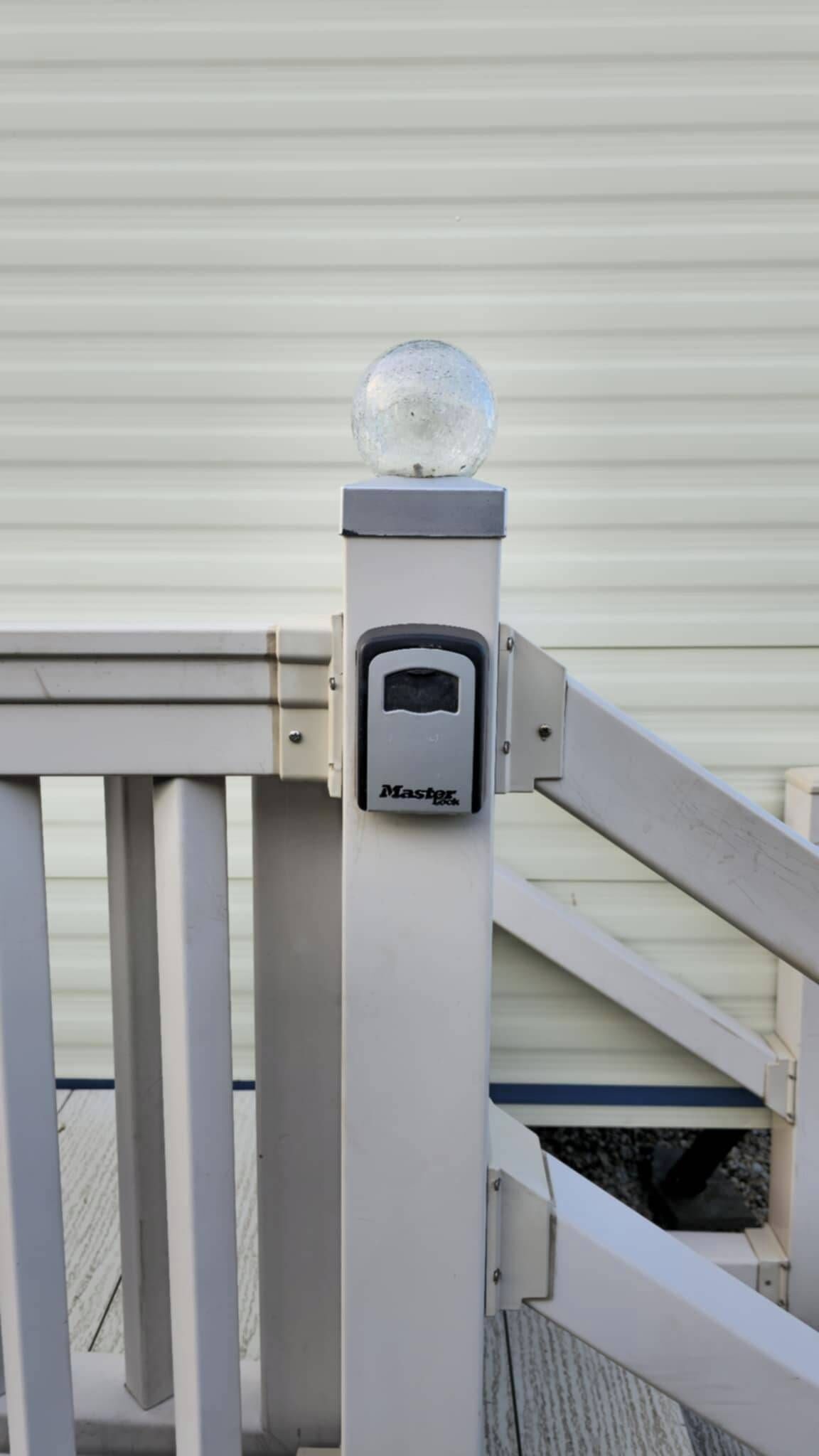 A security device with a spherical object on top, a rectangular panel with a keypad, and a metal gate structure.