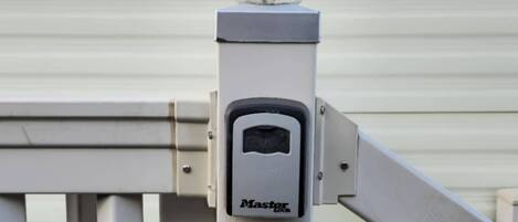 A security device with a spherical object on top, a rectangular panel with a keypad, and a metal gate structure.