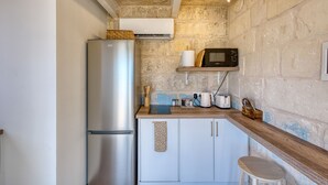 A compact kitchen with a stainless steel refrigerator, a microwave, and a wooden countertop. - Dar Vitorja (Senglea)