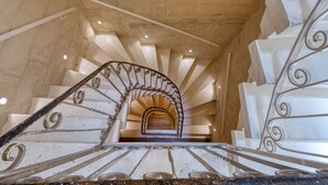A spiral staircase with ornate metal railings and a stone wall background. - Dar Vitorja (Senglea)