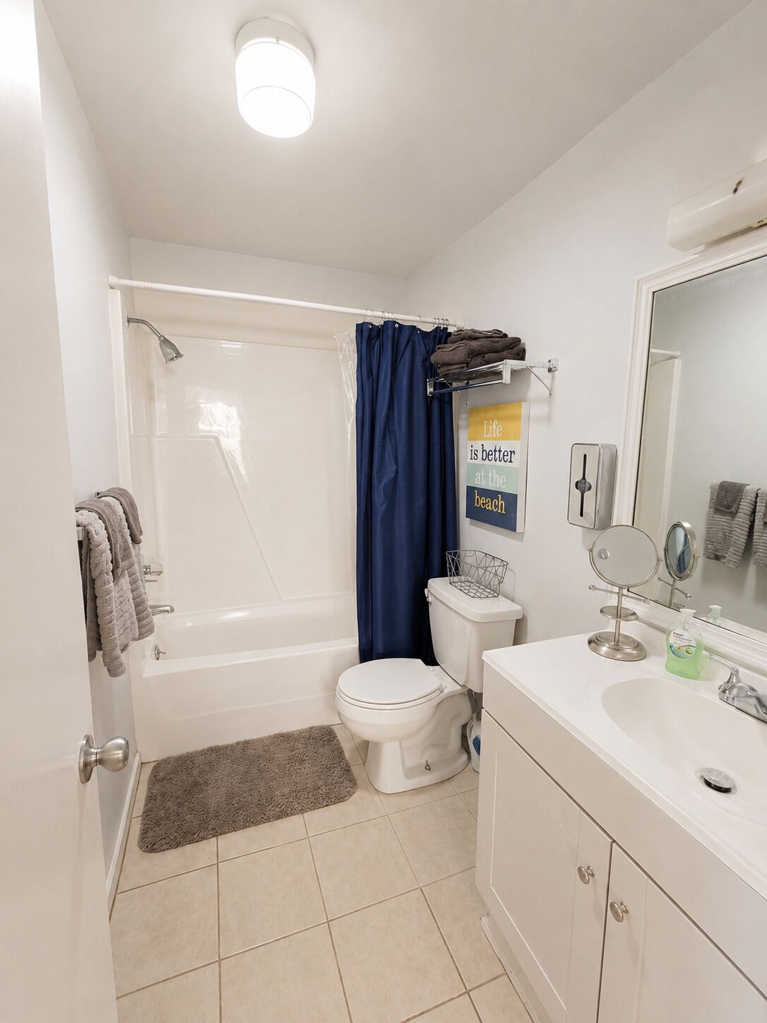 A bathroom with a bathtub, toilet, sink, and a mirror.