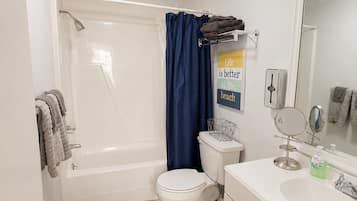 A bathroom with a bathtub, toilet, sink, and a mirror.