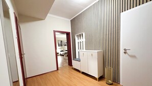 A hallway with wooden flooring, a white wardrobe, and a mirrored closet door. - Sophia Neighborhood - Spacious 92-square-meter basement apartment near Goethepark (Weimar)