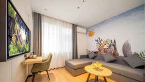 Una sala de estar moderna con un sofá, una mesa de centro, un televisor y un mural en la pared.