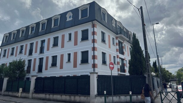 A multi-story building with a white facade and red accents, featuring a no entry sign, a gated entrance, and a street view. - The Cosy4 at Disneyland & Paris (Noisy-le-Grand)