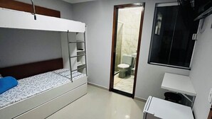 A compact room with a bunk bed, a small kitchenette, and a door leading to a bathroom. - Two-room suite equipped with air conditioning in the center of Arraial do Cabo, RJ. (Arraial do Cabo)