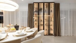 A dining area with a round table set for a meal, a display cabinet with various items, and a large chandelier. - Luxury villa Speranza with heated saltwater pool (VINJANI DONJI,IMOTSKI)