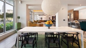 Un comedor moderno con una mesa grande, sillas y una lámpara esférica original.