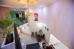 A hotel lobby with a chandelier, a painting of the Eiffel Tower, a staircase, and a seating area with chairs and a table. - Luxury 1 and 2 bedrooms house in nice Braives with cool AC (Braives)