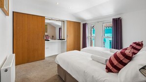 Een hotelkamer met een bed, een bureau, een kledingkast en uitzicht.