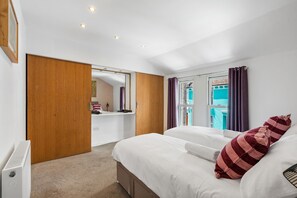 Ein Hotelzimmer mit Bett, Schreibtisch, Kleiderschrank und Blick ins Freie.