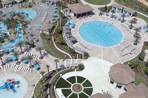 Ein Resort mit mehreren Schwimmbecken, Liegestühlen und einem zentral gelegenen Rundpool.