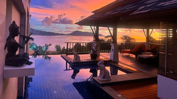 A rooftop infinity pool with a view of the sea and mountains, outdoor seating, and decorative statues. - Residence Disa – Panoramic sea views above Patong Bay, just steps from the beach (ตำบลป่าตอง)