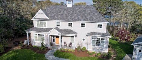 A two-story house with a front porch, a garage, and a well-maintained lawn.