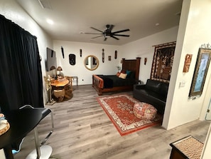 Un salon comprenant un lit, une table à manger et un ventilateur de plafond.