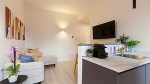 Een moderne keuken met een inbouwoven, een spoelbak en een flatscreen-televisie boven de aanrecht.