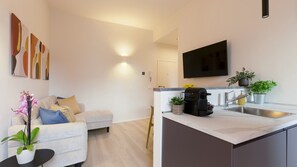A modern kitchen with a built-in oven, a sink, and a flat-screen TV mounted above the counter. - Tabata Home (Milano)