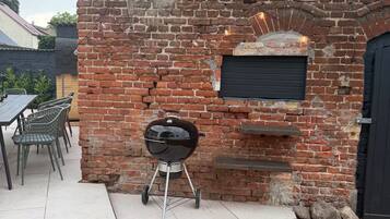 Ein Backsteinhaus mit Grill, Außenbereich und einer Laterne.