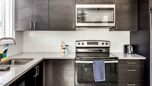 Une cuisine moderne équipée d’appareils électroménagers en acier inoxydable, d’un four à micro-ondes, d’un four et d’un grille-pain.