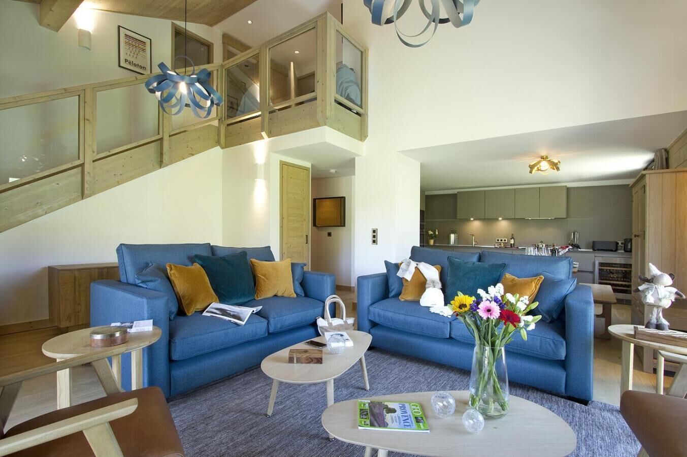 Un salon moderne avec un canapé bleu, une table basse et un vase de fleurs.