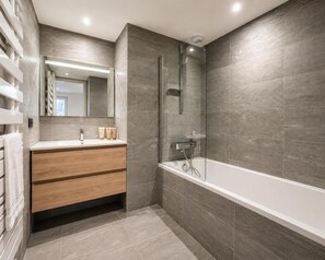 Ein modernes Badezimmer mit einer gläsernen Duschkabine, einem hölzernen Waschtisch und einem großen Spiegel.