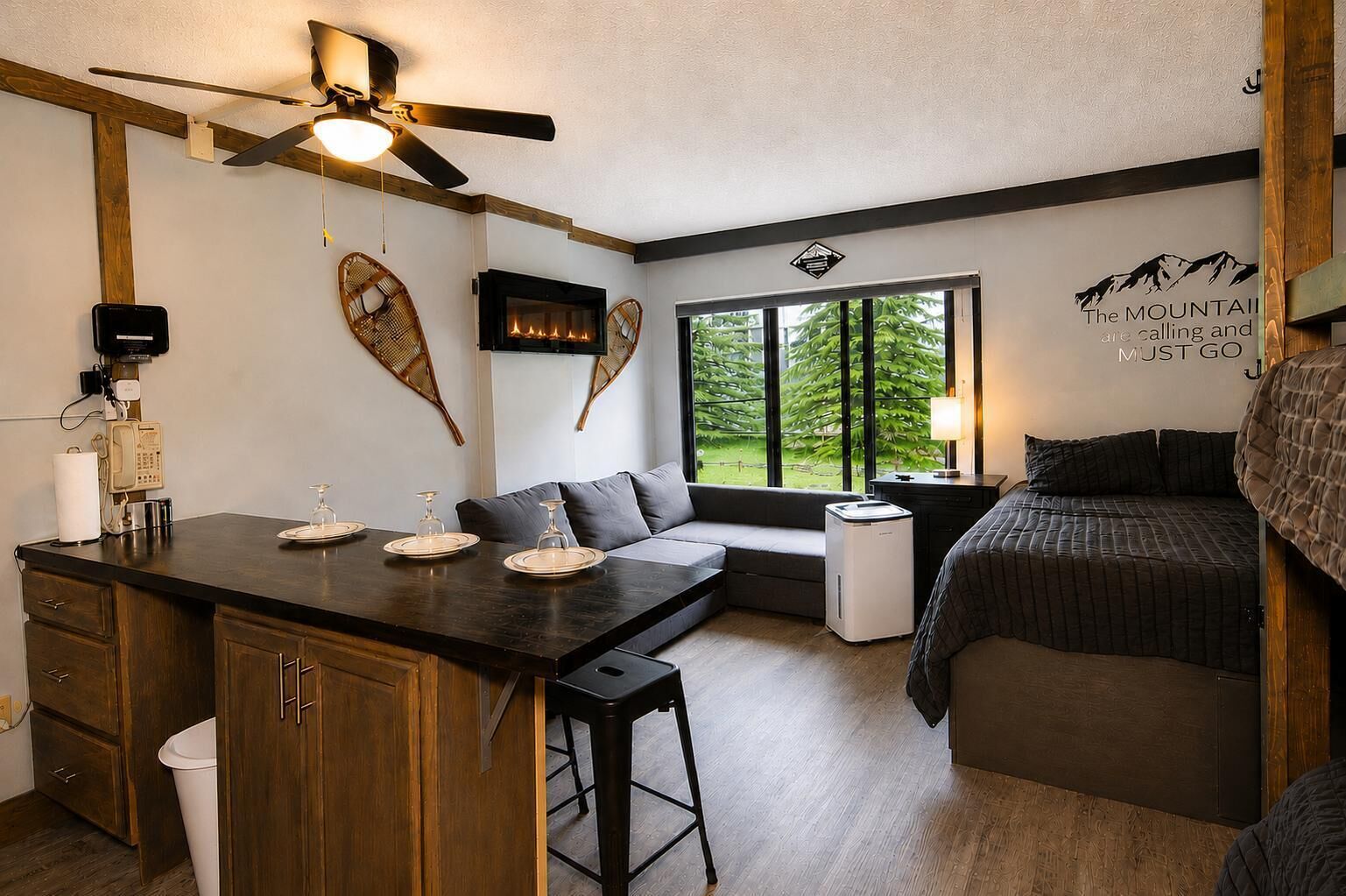 Ein gemütlicher Raum mit Küchenzeile, Essbereich, Sitzecke mit Blick und einem Bett.