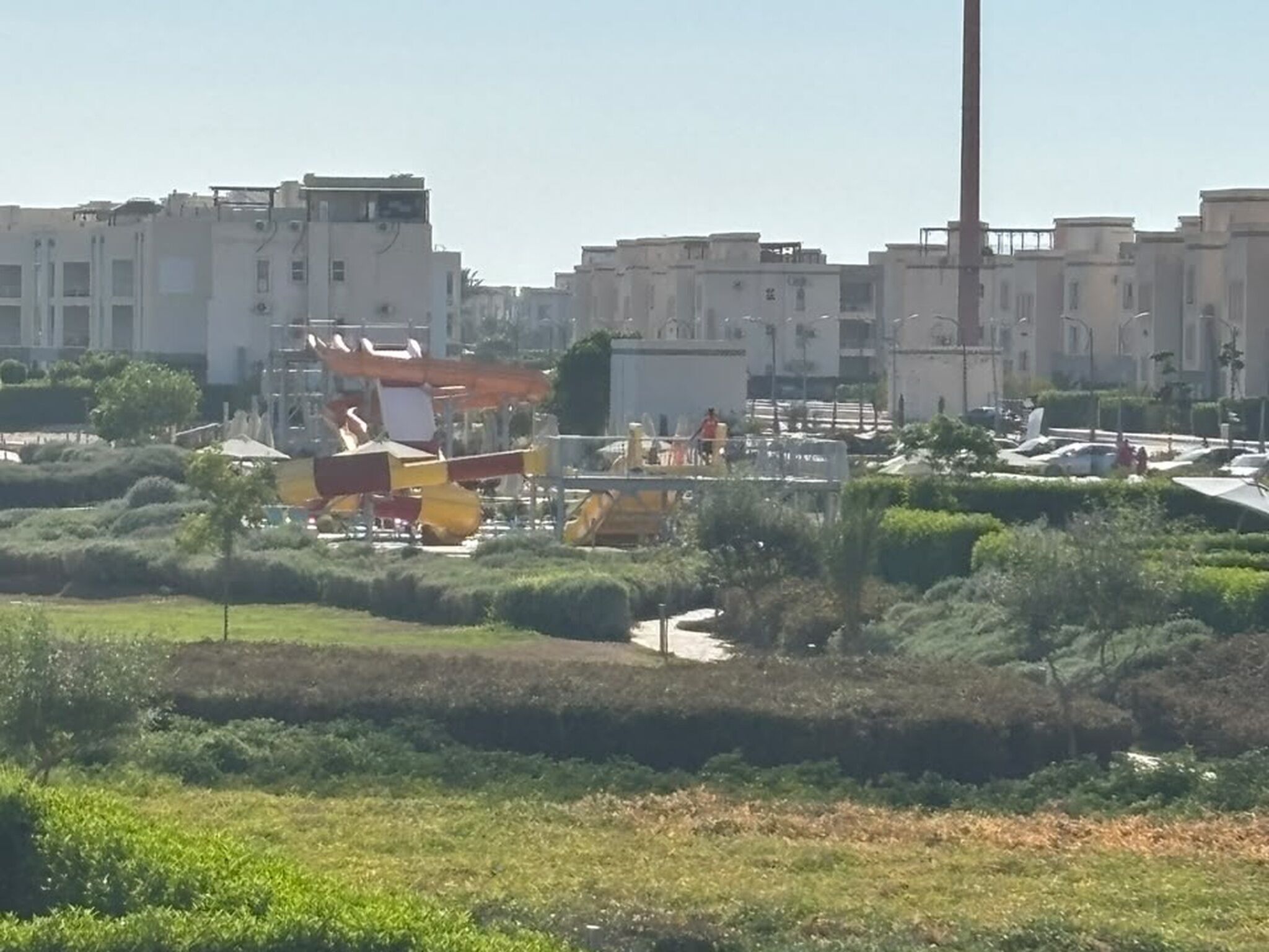 A residential area with modern buildings, a playground, and a parking lot.
