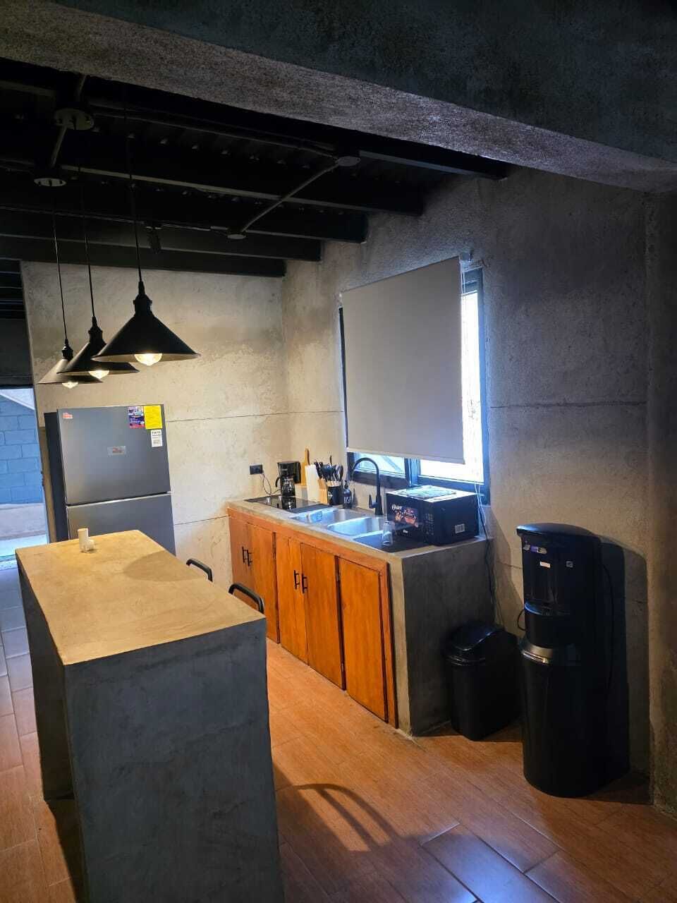 Eine kleine Küche mit Kühlschrank, Spüle und Kaffeemaschine.