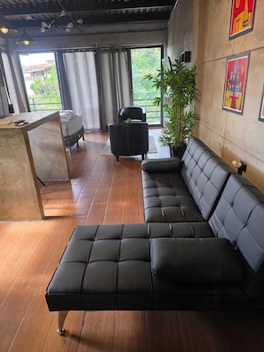 A modern lounge area with a sofa, a small table, and a potted plant.