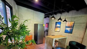 A modern interior with a kitchen area, seating, and artwork on the walls.