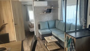 Un soggiorno moderno con un divano, un tavolino da caffè e una zona pranzo con una sedia.