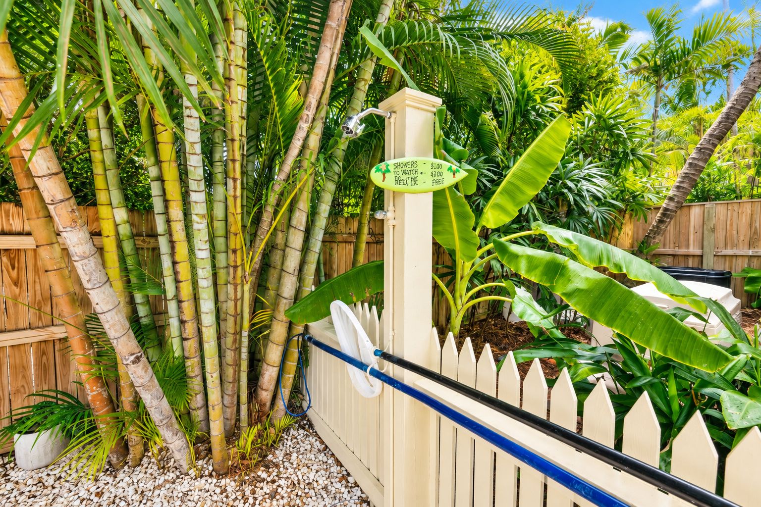 A bamboo fence with a sign indicating showers and a price of $100.