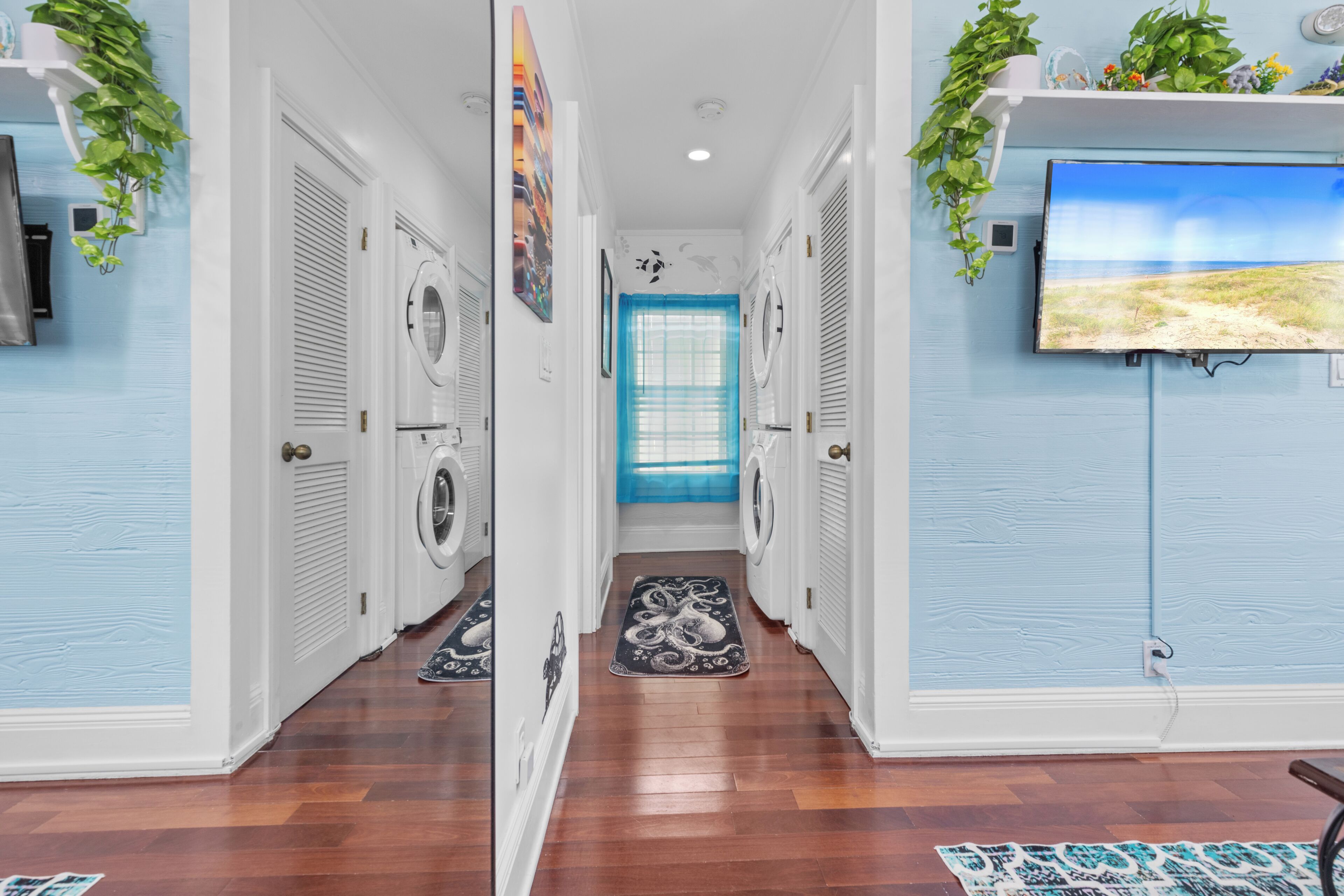 A laundry room with a washing machine, dryer, and a blue door.
