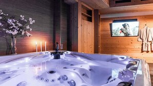 Un bain à remous dans une pièce en bois, avec un mur en bois et un tableau encadré.