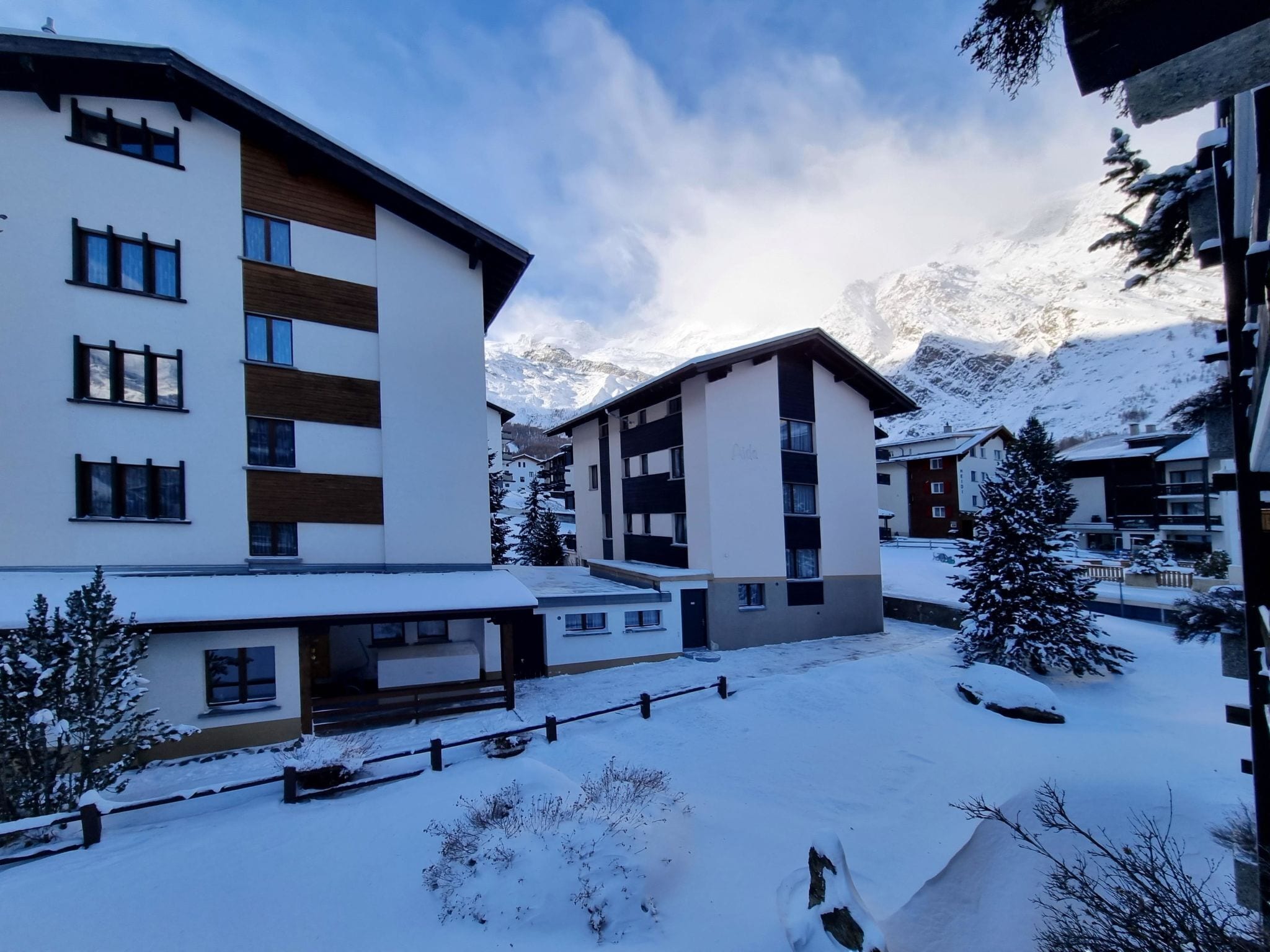 Un edificio moderno con múltiples ventanas y suelo cubierto de nieve.