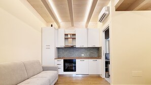 Eine moderne Küche mit weißen Schränken, einem Einbauofen und Holzboden.