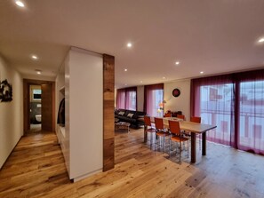 A modern living space with a dining area, wooden flooring, and a view through large windows. - Gletschergarten Appartement/Fewo 6-Bettwohnung by Interhome (Saas-Fee)