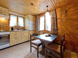A wooden cabin interior with a kitchen, dining table, and chairs. - Maria Appartement/Fewo 4-Bettwohnung Nr. 5 by Interhome (Saas-Fee)