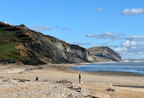 Ein felsiger Strand mit Klippen und blauem Himmel.