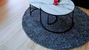 A living room with a black sofa, a round coffee table, and a large window. - Cabane 3 Appartement/Fewo Holiday-Schöner Wohnen by Interhome (Saas-Fee)