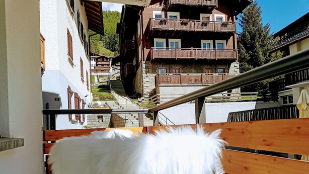 A staircase with a wooden railing and a white fluffy object on it. - Cabane 3 Appartement/Fewo Holiday-Schöner Wohnen by Interhome (Saas-Fee)