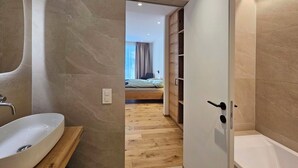 A modern bathroom with a large sink, a shower, and a wooden vanity. - Silberdistel EG Appartement/Fewo Appartement/Fewo by Interhome (Saas-Fee)