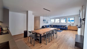 A modern living space with a dining area, a sofa set, and a kitchen area. - Silberdistel EG Appartement/Fewo Appartement/Fewo by Interhome (Saas-Fee)