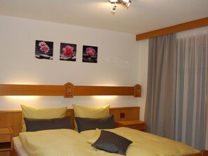 A hotel room with a bed, two bedside tables, a headboard, and three framed pictures on the wall. - Swiss Chalet Appartement/Fewo 2-Bettwohnung Nr. 7 by Interhome (Saas-Fee)