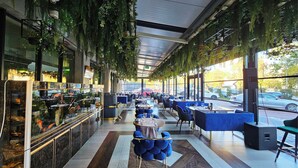 A restaurant with indoor seating, a bar area, and large windows.