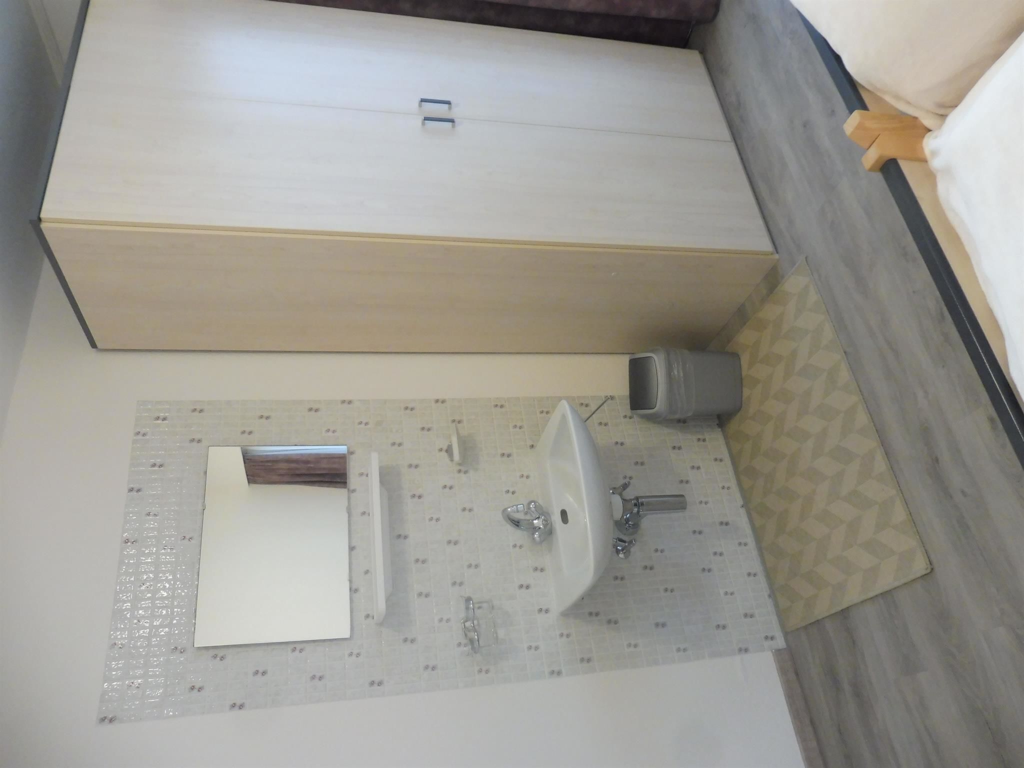 A bathroom with a large white cabinet, a sink, and a mirror.
